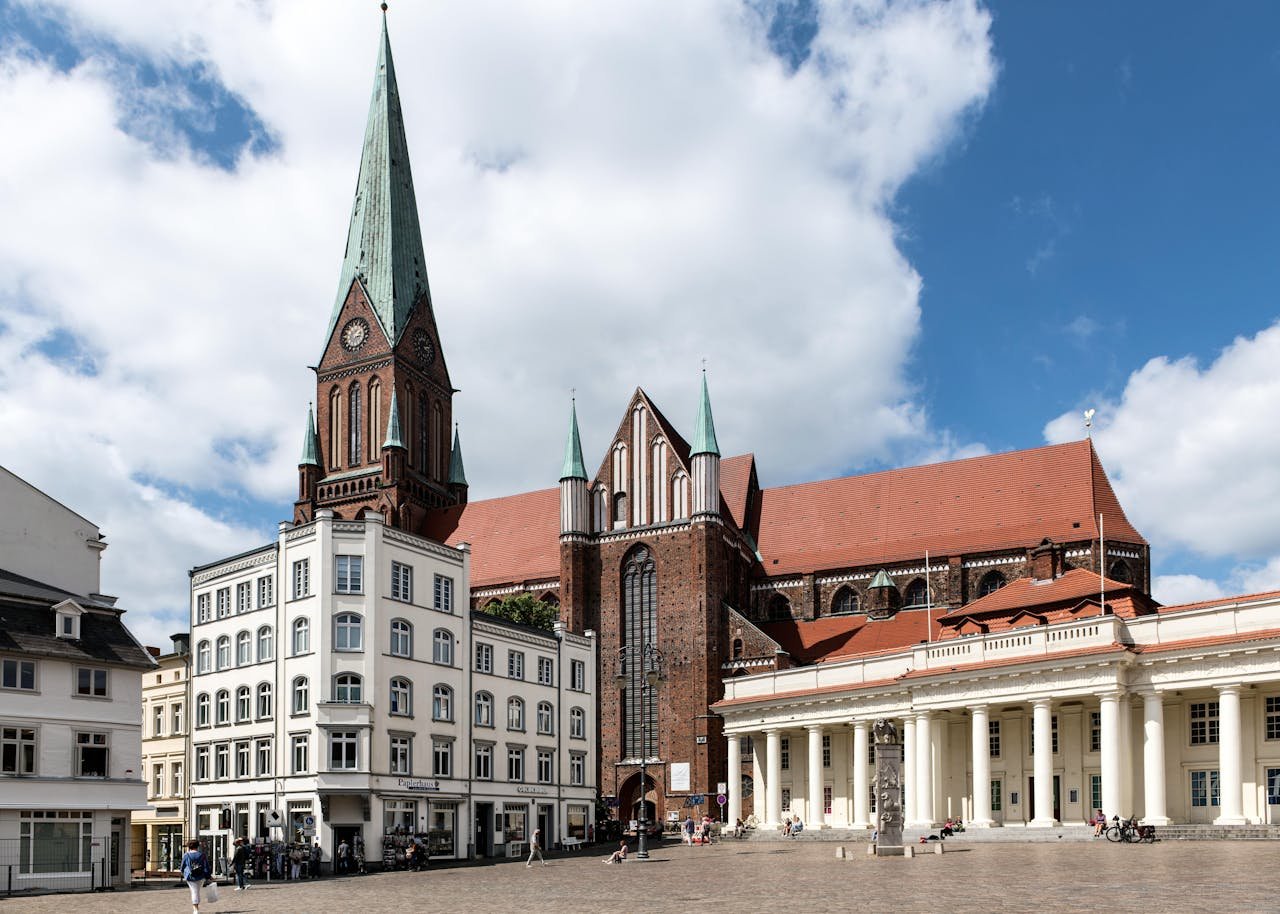 View of Schwerin Cathedral and Market Square in Germany with historic architecture under a blue sky.